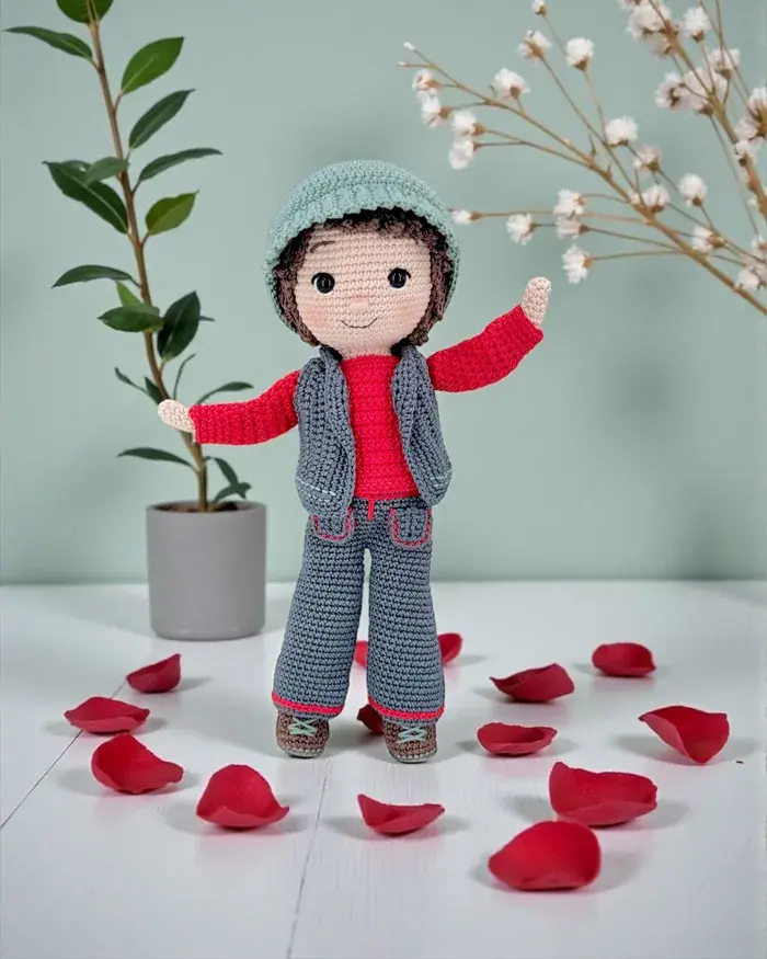 Valentin, la poupée au crochet, au milieu de pétales de rose